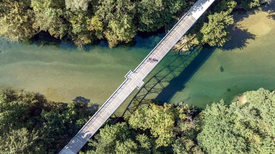 most ponad rieku, na nom idu dvaja cyklisti