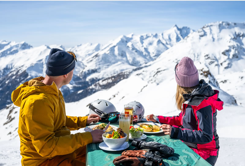 muz,zena,zima,alpy,lyzovanie,jedlo,terasa,chata,helma