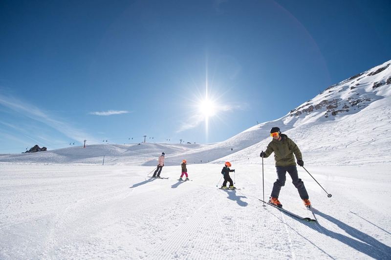 dvaja dospeli,dve deti,zjazdovka,lyzovanie,zima,Alpy