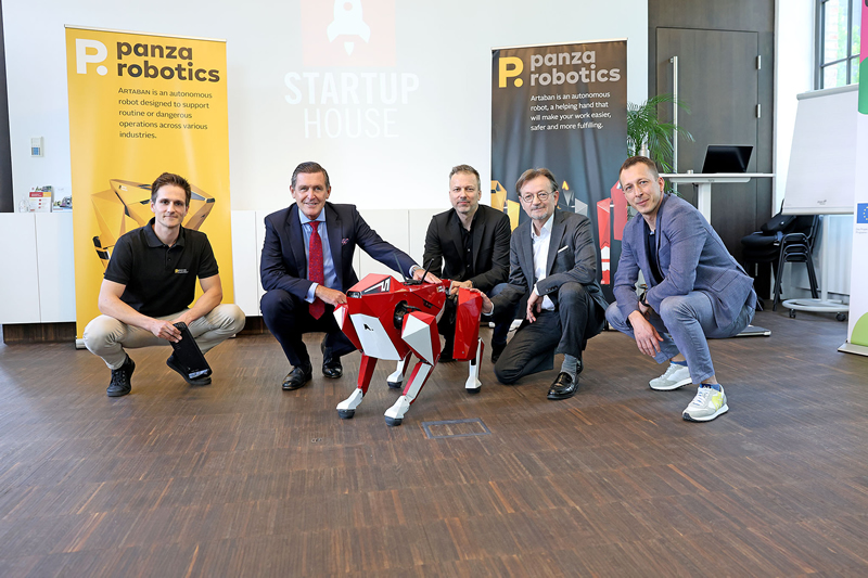 foto majitelov Panza Robotics s mestskym radcom Viedne Hankeom a maly robot v podobe psa